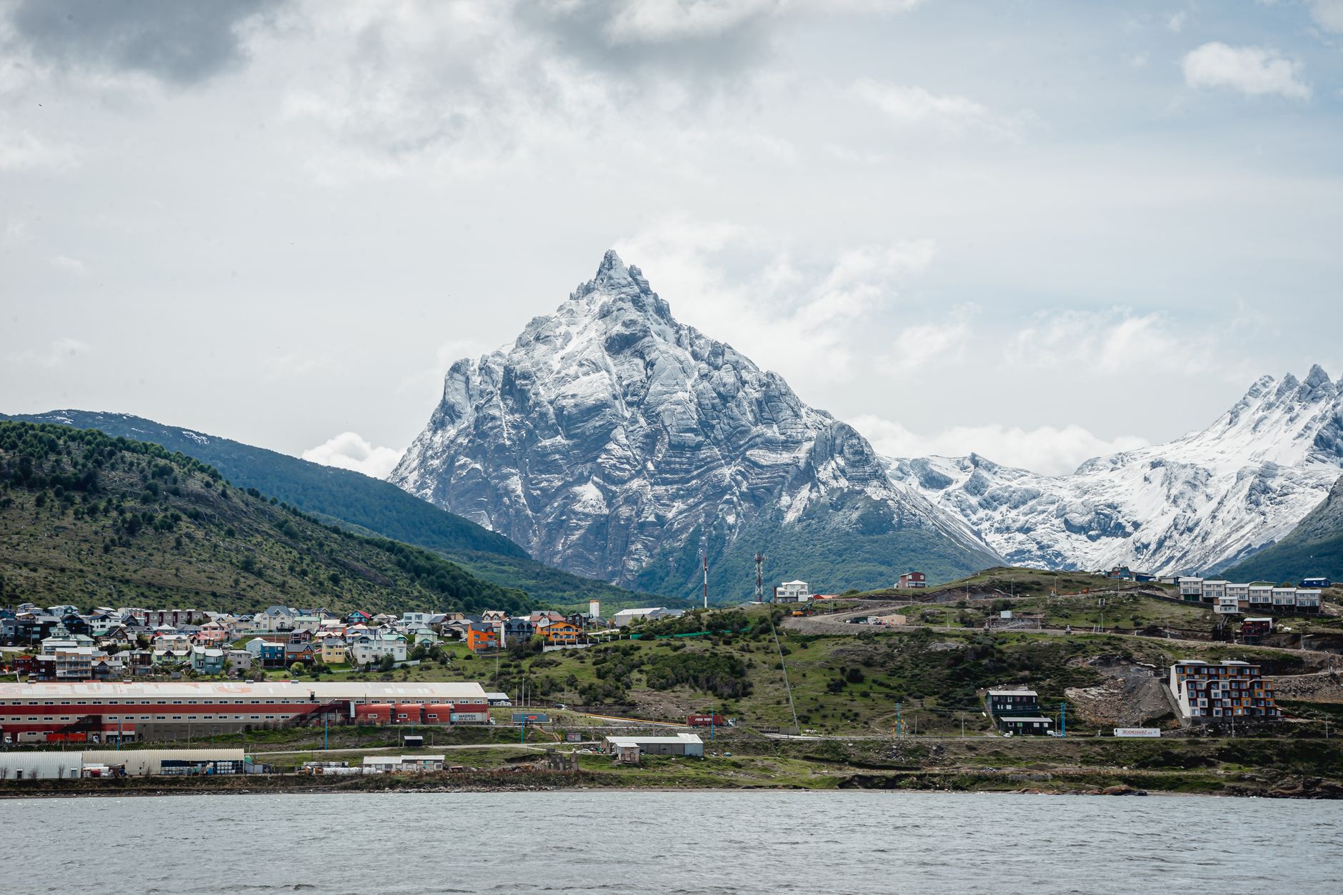 A breathtaking view of the snow-covered mountains towering over the cityscape of Ushuaia, Argentina.