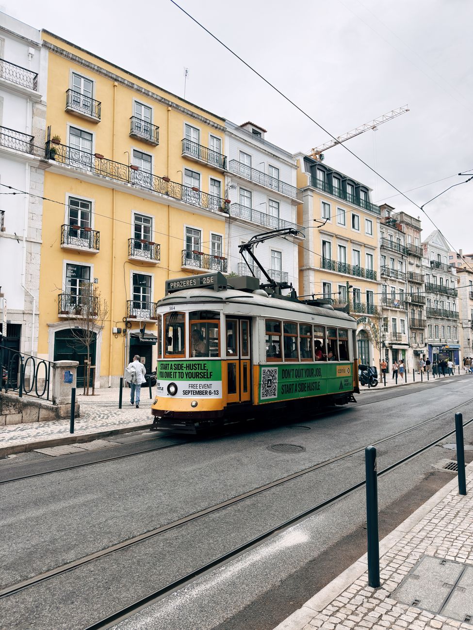 Iconic Lisbon tram traversing picturesque street lined with classic architecture.
