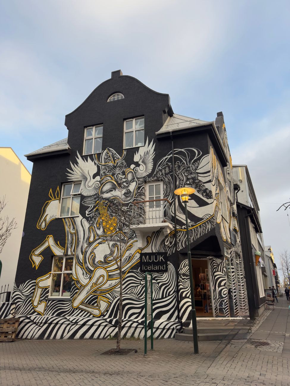 Colorful mural decorates a building facade in Reykjavik, Iceland, showcasing unique street art style.